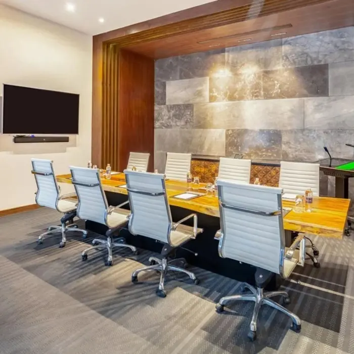 Sleek boardroom with modern design, leather chairs, and wood-accented meeting table.