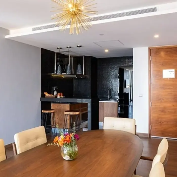 Upscale suite dining area with floral centerpiece, kitchen bar, and modern lighting.