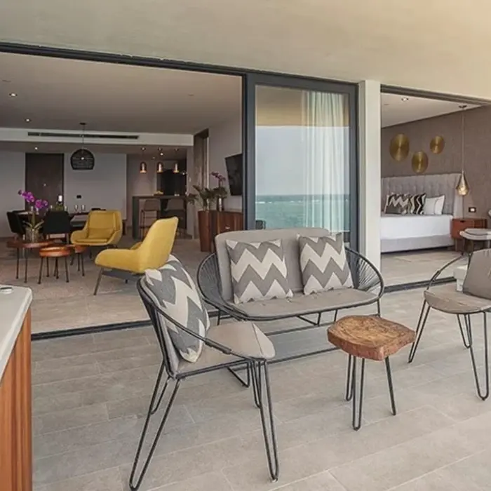 Spacious balcony with seating, outdoor jacuzzi, and direct access to the interior suite with ocean views.