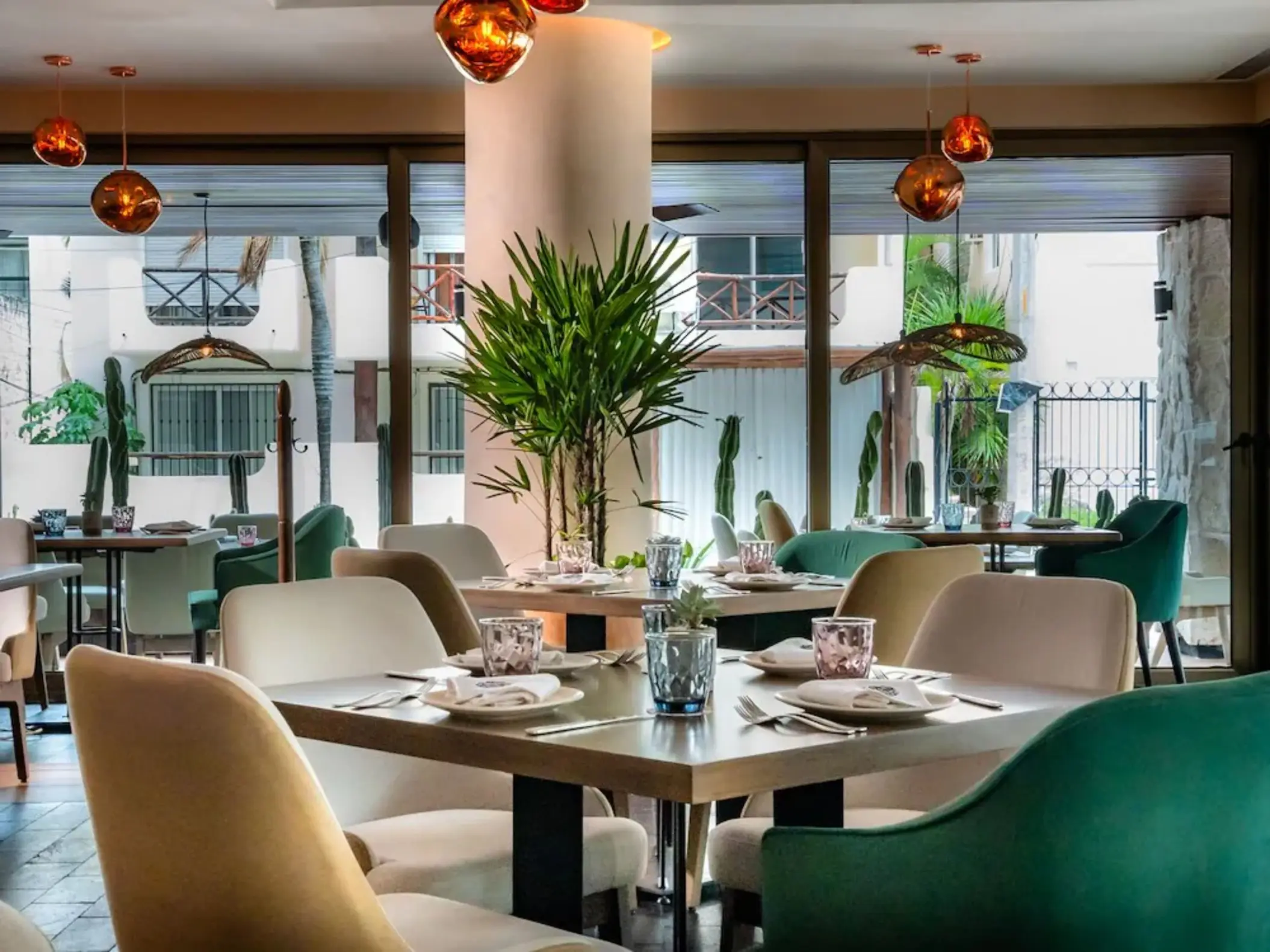 Interior of Cachito Cocina Mexicana at The Reef 28, showing elegant dining tables and chairs with warm lighting.