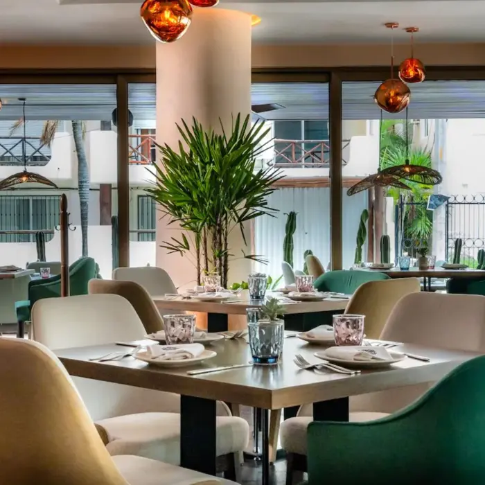 Interior of Cachito Cocina Mexicana at The Reef 28, showing elegant dining tables and chairs with warm lighting.