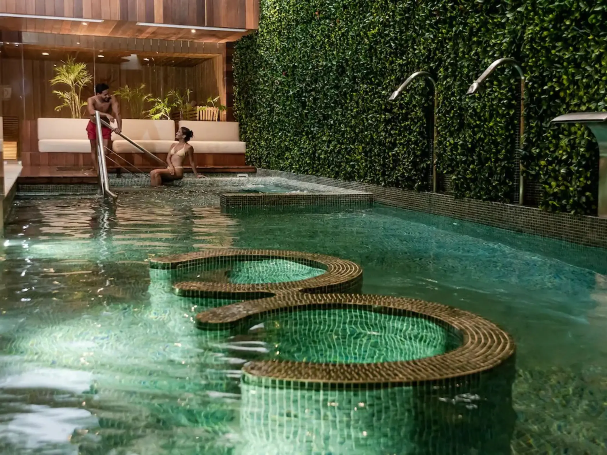 A wide shot of the serene hydrotherapy circuit pool with seating at The Reef 28's Okom Spa.