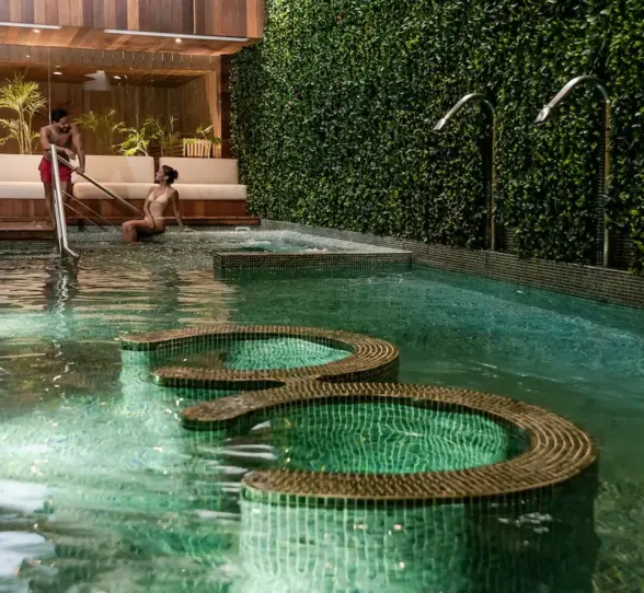 A wide shot of the serene hydrotherapy circuit pool with seating at The Reef 28's Okom Spa.