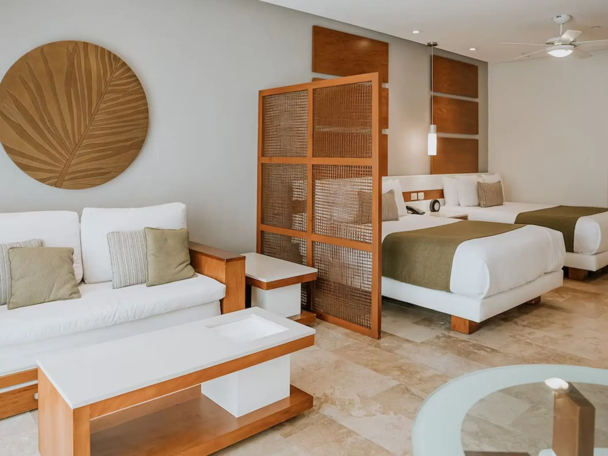 A spacious junior suite at The Reef 28 featuring two queen-size beds and a comfortable living area with modern decor.