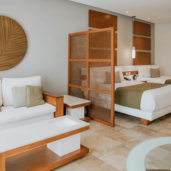 A spacious junior suite at The Reef 28 featuring two queen-size beds and a comfortable living area with modern decor.