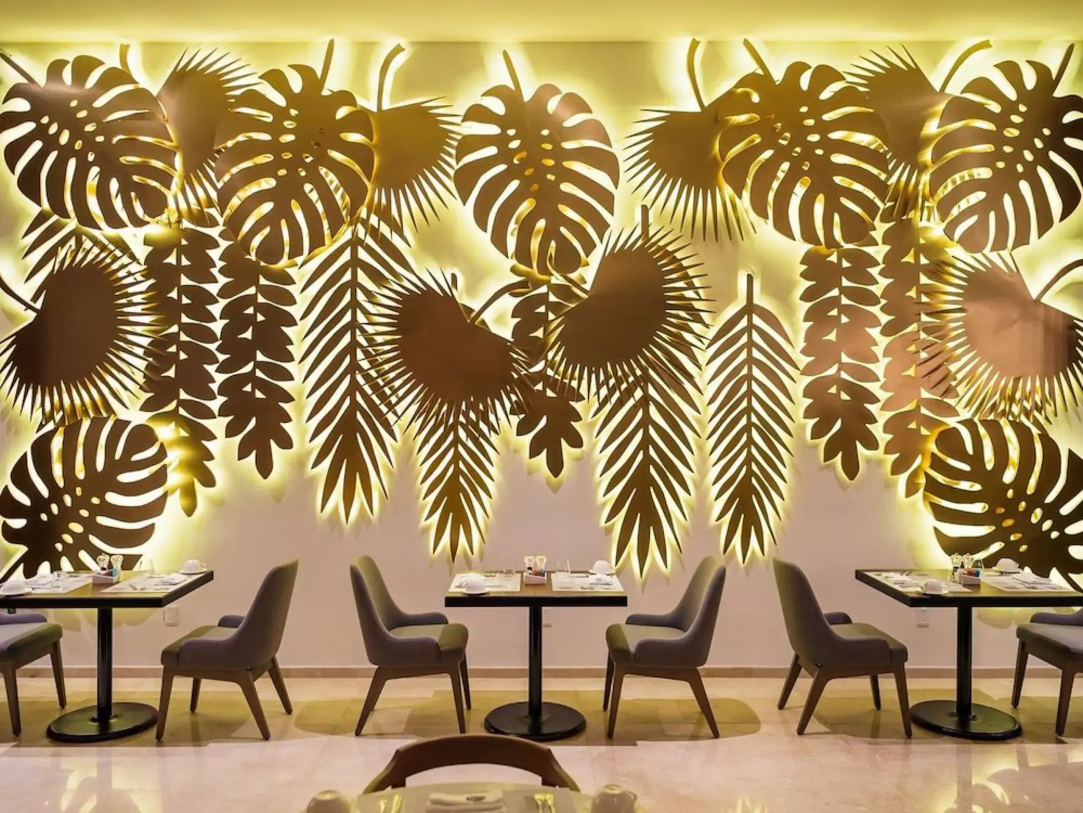The interior of Veinti8cho buffet restaurant at The Reef 28, featuring elegant seating and decorative backlit wall art.