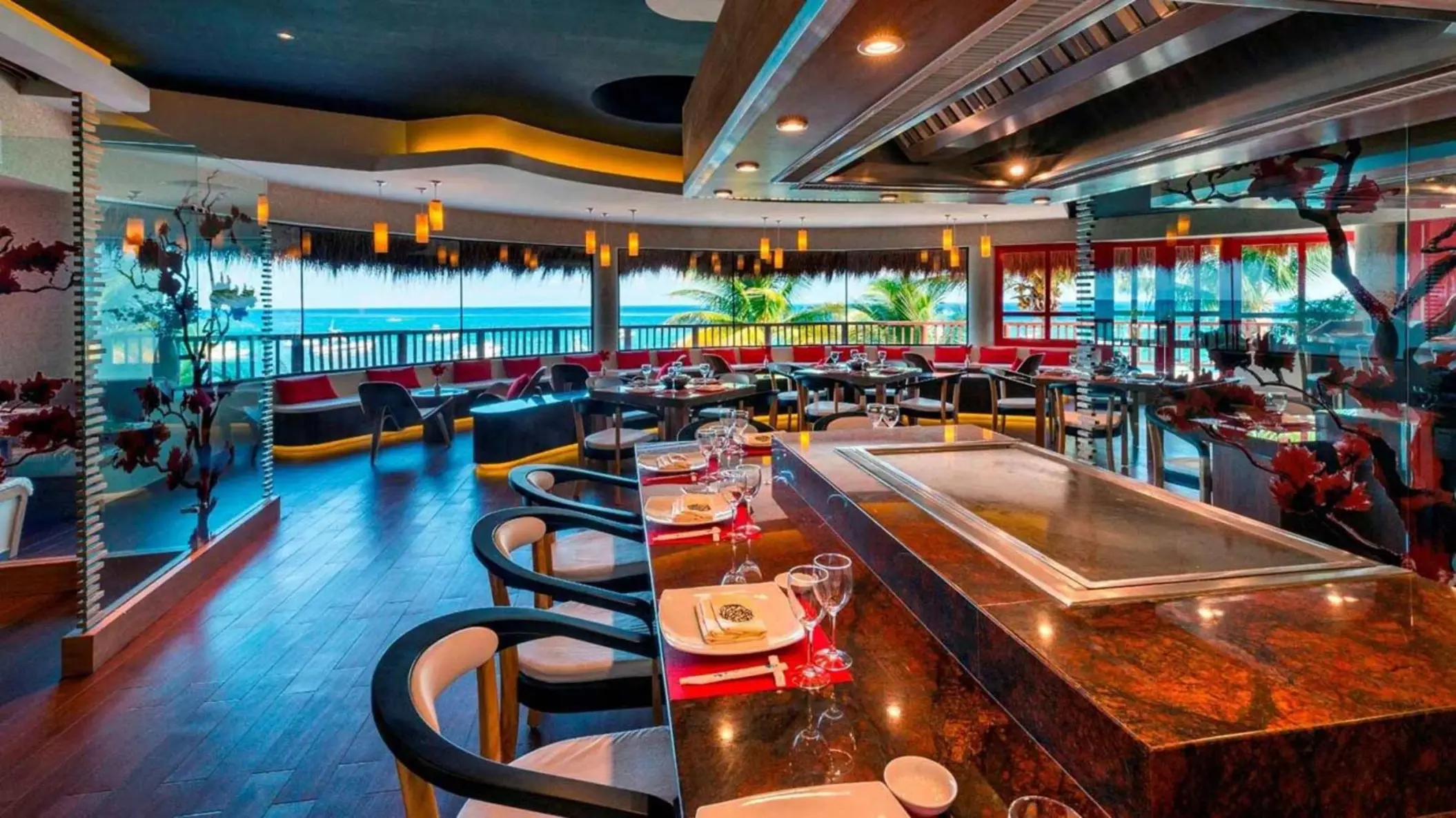 A modern restaurant with a sushi or hibachi bar and a panoramic view of the beach.