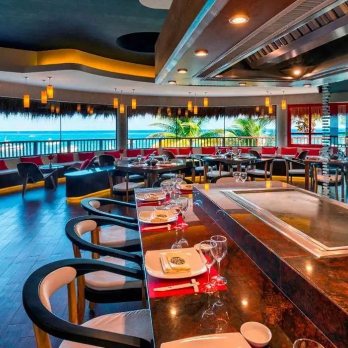 A modern restaurant with a sushi or hibachi bar and a panoramic view of the beach.