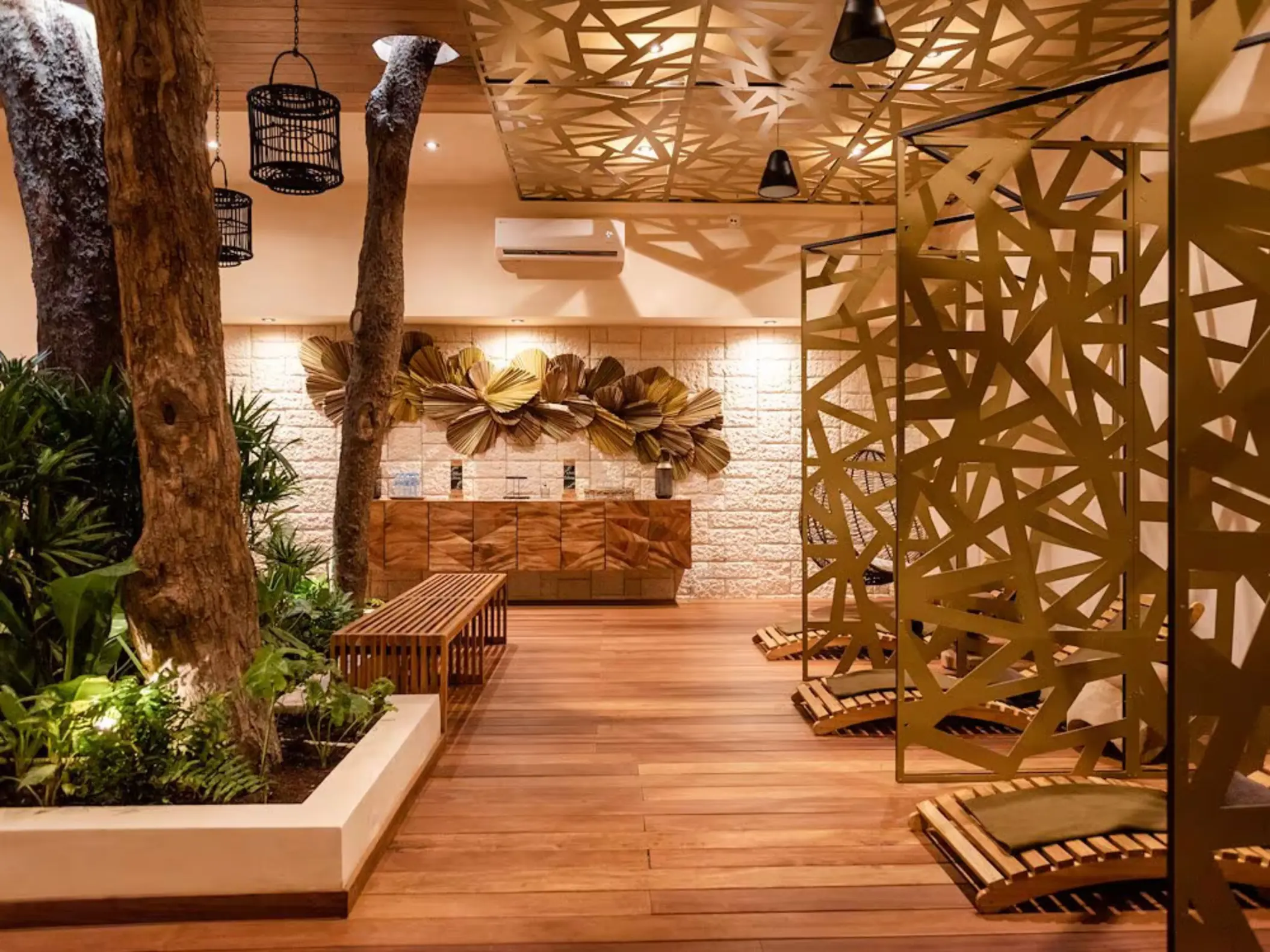 The serene interior of the Ome Spa at The Reef Playacar, with natural wood elements, unique decor, and seating areas.