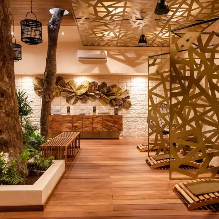 The serene interior of the Ome Spa at The Reef Playacar, with natural wood elements, unique decor, and seating areas.