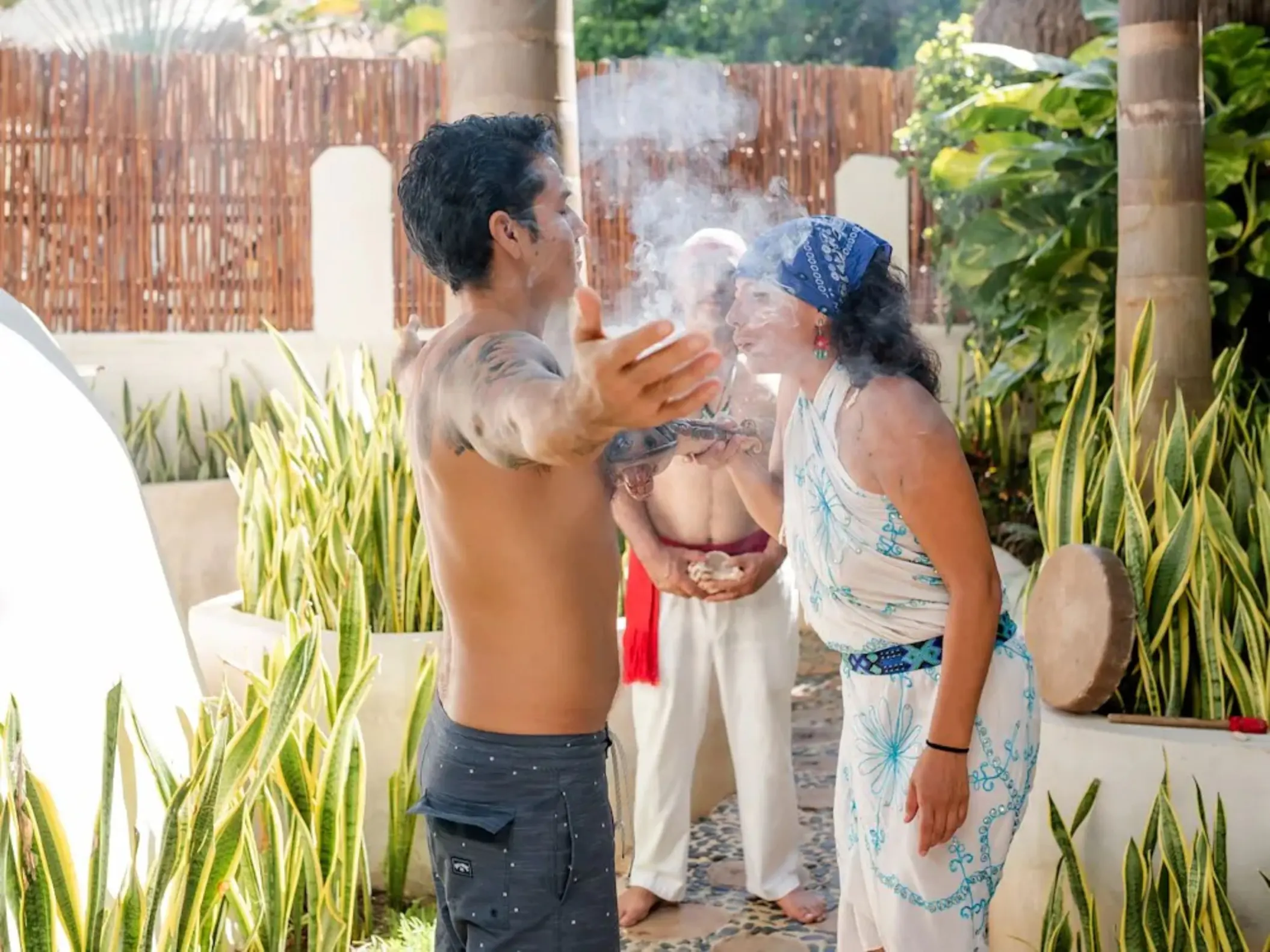 Participants engaged in a spiritual Temazcal ceremony at The Reef Playacar, with smoke, natural surroundings, and traditional elements.