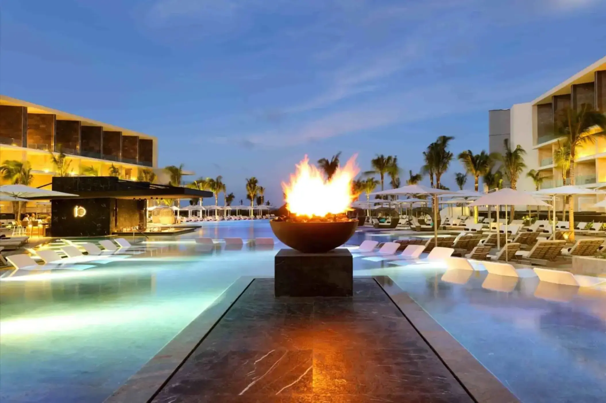fire pit lit up near the pool in the evening at trs coral hotel
