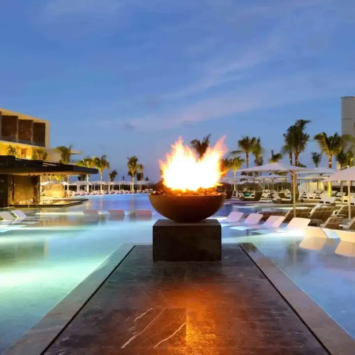fire pit lit up near the pool in the evening at trs coral hotel