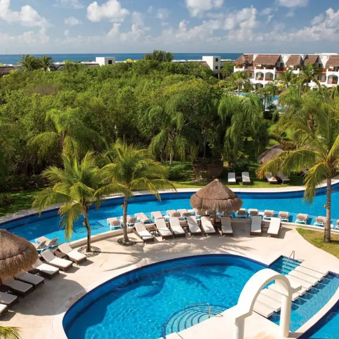 pool and loungers and resort buildings at Valentin Imperial Riviera Maya