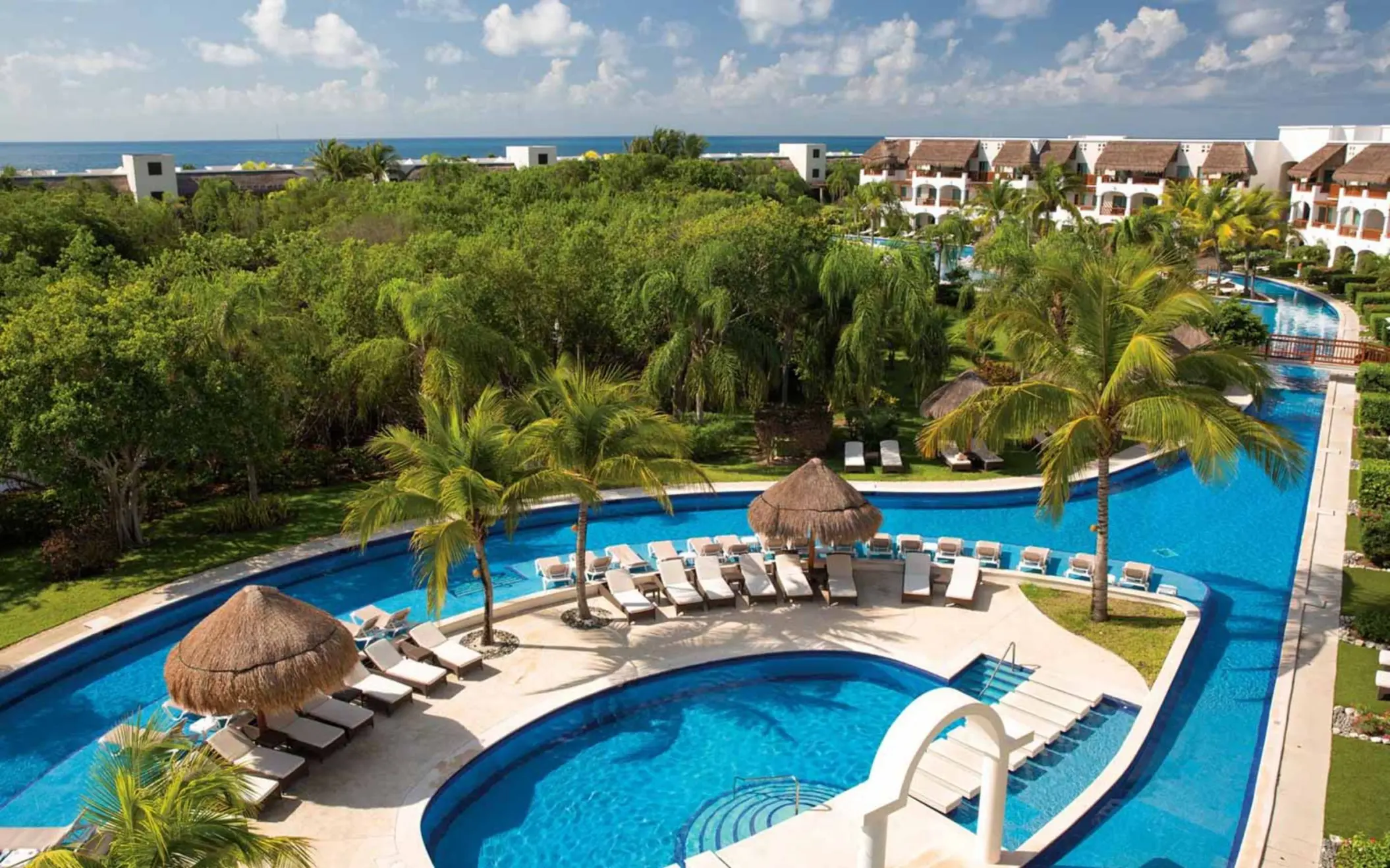 pool and loungers and resort buildings at Valentin Imperial Riviera Maya