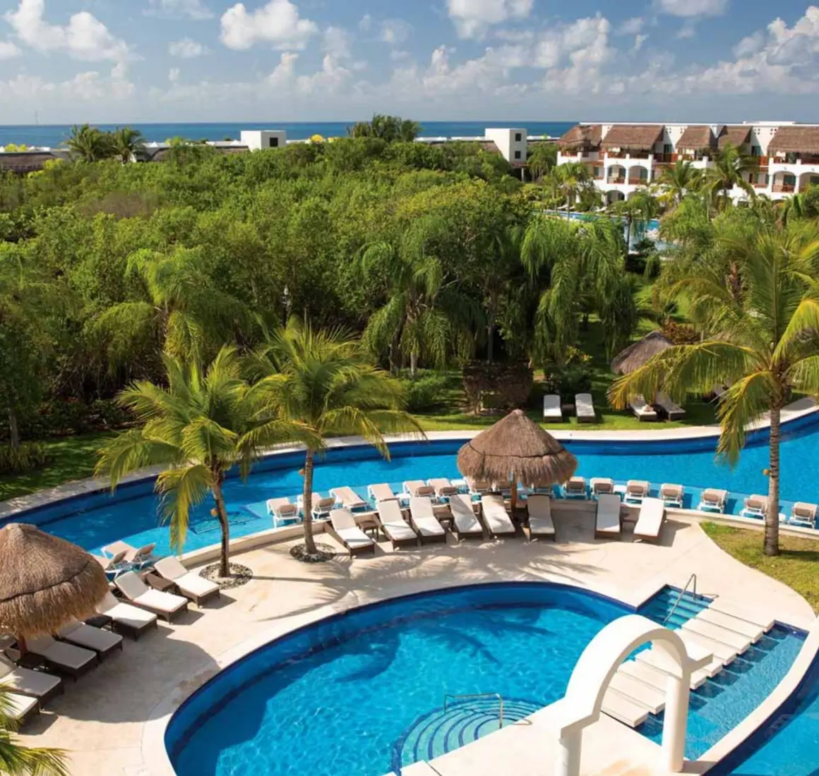 pool and loungers and resort buildings at Valentin Imperial Riviera Maya