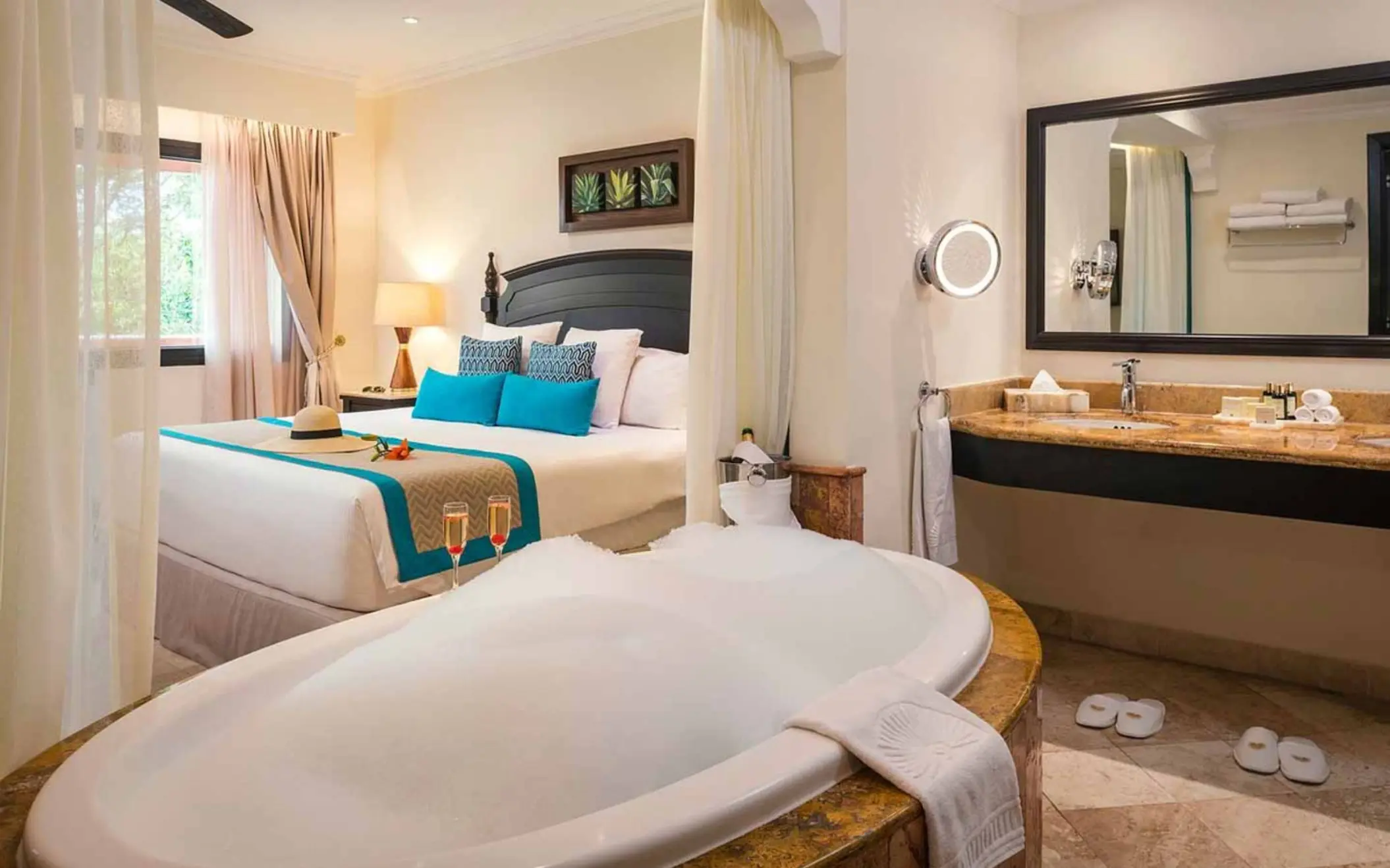 washroom with bathtub and view of king bed at Valentin Imperial Riviera Maya
