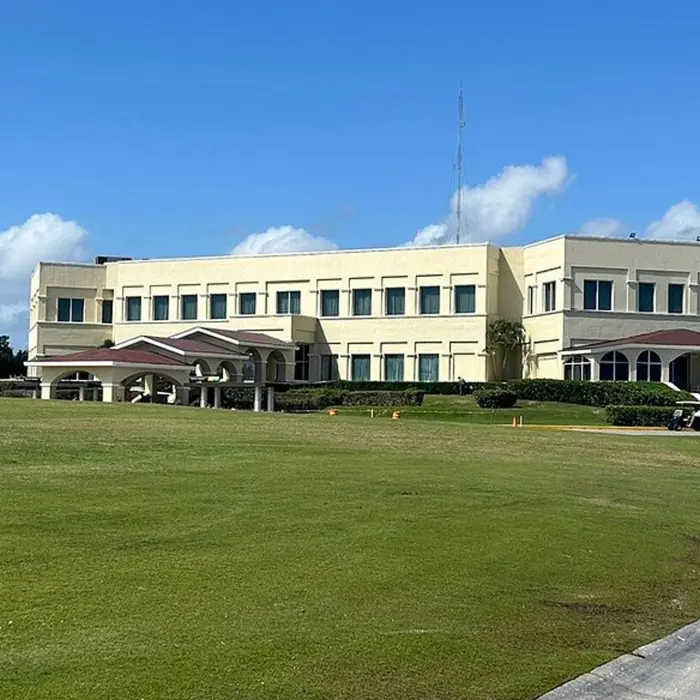 The grand exterior of the luxury clubhouse at Moon Palace Golf Course, featuring elegant architecture and an expansive green fairway
