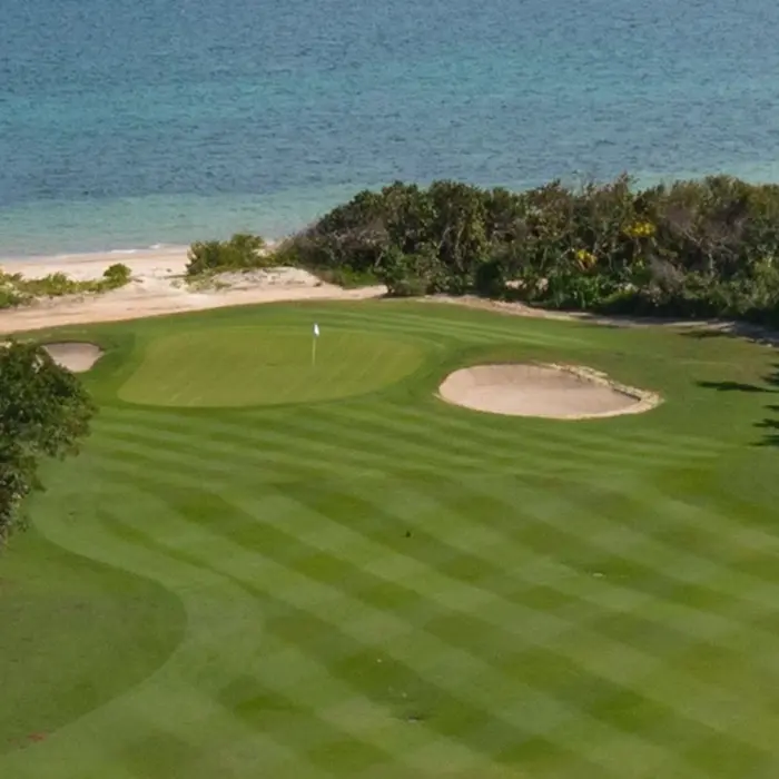 A stunning oceanfront golf green bordered by white sand beaches and the crystal-clear turquoise waters of the Caribbean Sea.